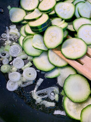 Zucchine tagliate a rondelle e cipolla in padella. Cibo sano e vegetariano. Direttamente sopra.