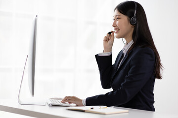 Telephone operator works with computer in office and talks with customers.