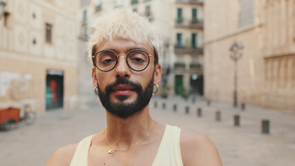 Handsome guy with blond hair wearing glasses smiles looks at camera