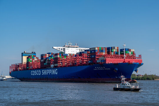Hamburg, Germany - 04 17 2023: View of the container ship CSCL Pacific Ocean of the shipping company Cosco Shipping on the Elbe in Hamburg.