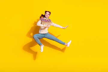Photo portrait of attractive young woman jumping kick karate dressed stylish knitted warm outfit isolated on yellow color background