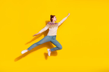 Photo portrait of attractive young woman jump flying superhero dressed stylish knitted warm outfit isolated on yellow color background