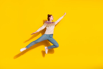 Obraz premium Photo portrait of attractive young woman jump flying superhero dressed stylish knitted warm outfit isolated on yellow color background