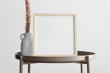 Wooden square frame mockup with a pampas decoration on the beige table.