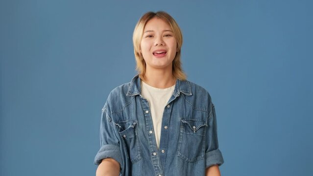 Frustrated young woman asks why isolated on blue background
