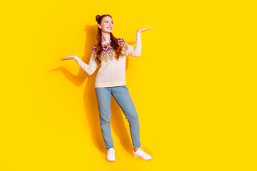 Photo portrait of attractive young woman compare look empty space dressed stylish knitted warm outfit isolated on yellow color background