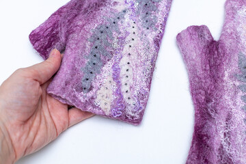Person holding purple fabric with a pattern, resembling a petal, in their hand