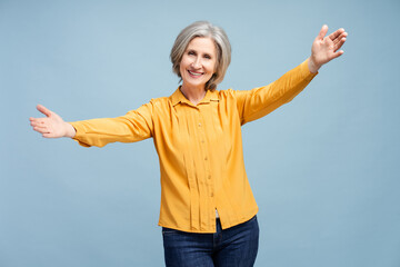 Portrait of happy senior woman wearing casual outfit hugging looking at camera isolated