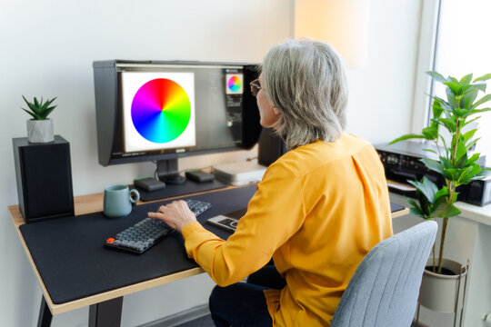 Graphic designer, editor, retoucher using graphic tablet sitting at workplace