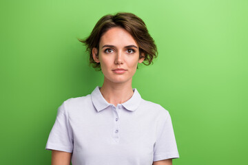 Portrait of attractive young confident woman golf club coach wearing basic pastel purple t shirt polo isolated on green color background