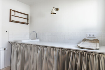 A laundry room with a porcelain sink and a vintage wooden drainer