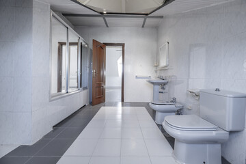 A very spacious bathroom, gray sanitary fixtures and a bathtub with sliding screens with mirrors