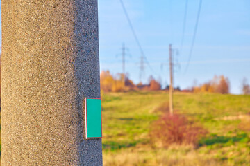 A pole with a sign on a high-voltage power line