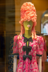 Creative female mannequin in a high retro wig and protruding rag lips. A mixture of centuries and...