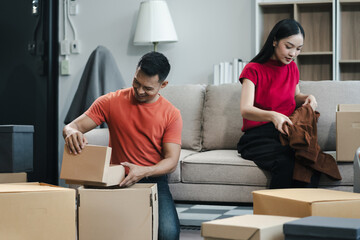 young couple helps put things in boxes and prepares to move to a new house.