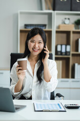 Businessman using laptop computer and smartphone  in office. Happy woman, entrepreneur, small business owner working online.