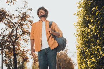 Photo of handsome cheerful hispanic man dressed stylish clothes walking alone enjoying nature park...