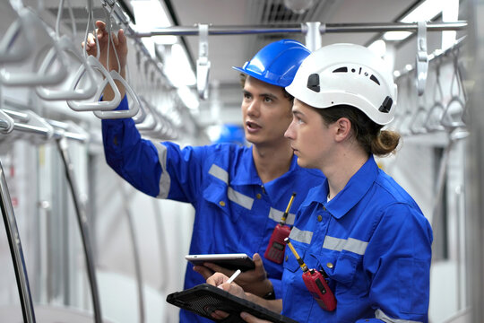 Electric train technician engineer checking controls system for security functions in maintenance infrastructure plant of sky train, public transportation vehicle,Teamwork management concept.