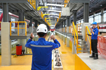 Electric train technician engineer checking controls system for security functions in maintenance infrastructure plant of sky train, public transportation vehicle,Teamwork management concept.