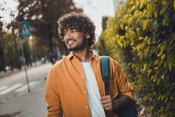 Photo of cheerful indian man wearing stylish clothes going home after college lectures nice sunny weather outside