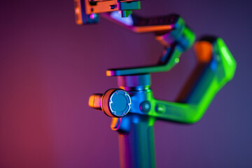 Close up on a modern gimbal for videomaking, background is black.