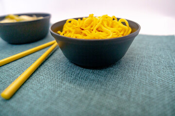 Yakisoba in lunchbox and bowl with chopsticks Chic Asian food