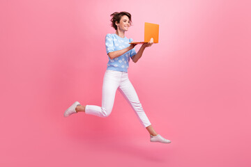 Full length profile photo of overjoyed person jump use wireless laptop coworking isolated on pink color background