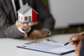 Businessman, real estate agent negotiating the signing of a home purchase agreement.