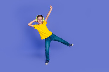 Photo of cheerful positive boy wear trendy yellow clothes listen music dance listen hit sound song isolated on purple color background