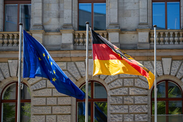 Waving German and European Union flag against the background of a historical building. German flag...