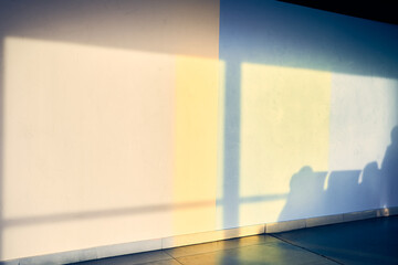 An abstract background depicting the shadow of a row of chairs on a white wall at the airport, with...