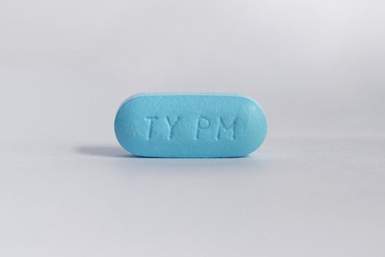 single blue tablet pill of Tylenol PM, pain reliever and sleep aid with acetaminophen and antihistamine on a white background, copy space