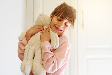 Happy girl, hug and love with teddy bear for comfort, soft toy or playful doll at home. Little...