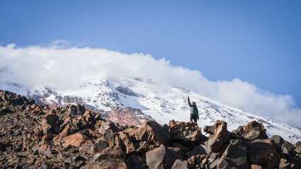 Happy man standing with his hand up after reaching the false summit, Mount Ararat in Turkey
