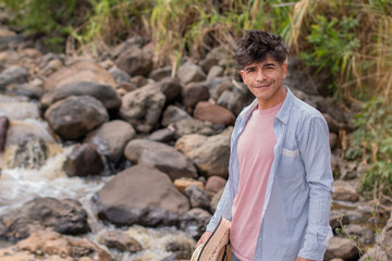 lifestyle. young latin man smiles by a river