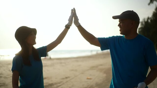 Teamwork moment of volunteer people group in volunteering charity activities cleaning up waste plastic on sand sea ocean beach . Corporate social responsibility and society activity for Environment.