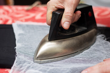 A person presses a fabric with their finger on a table