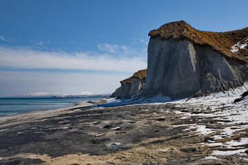 Russia, the Far East, the Kuril Islands. One of the main attractions of Iturup Island is the destructive pumice mountains on the coast of the Sea of Okhotsk. - obrazy, fototapety, plakaty