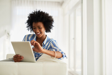 Black woman, home and happy sofa with tablet for social media post and entertainment. Female...