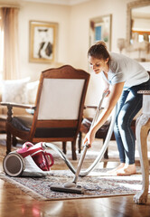 Woman, cleaning and vacuum with carpet in living room for house work, natural light and furniture....