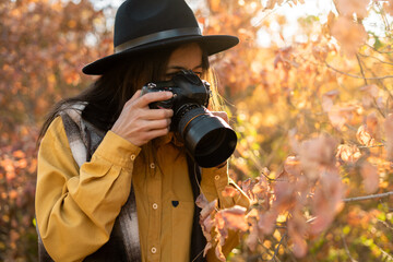 Using camera, close-up of female photographer during shooting landscape view
