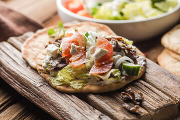 Greek gyros wrapped in pita breads on a wooden background