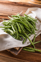 Fresh young beans pods. Old wooden background. Green string beans crop conception