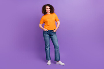 Full length photo of cute thoughtful woman wear orange t-shirt looking empty space isolated purple color background