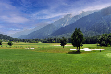 A beautiful view of lush green golf course surrounded by beautiful hills with pine trees at Pahalgam Kashmir India.