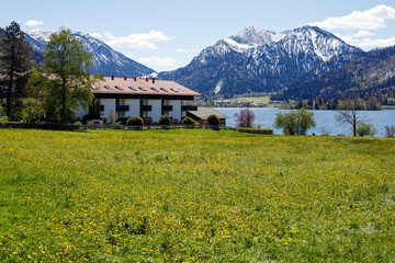 beautiful alpine landscape in bavaria. lakeside house with mountain views in the snow