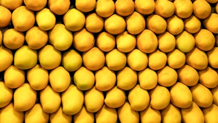 Fruit backdrop with neatly arranged yellow mangoes at a market, reflecting the global trend towards...