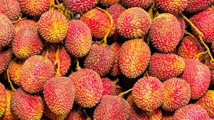 Fruit backdrop with bright red lychees clustered together, epitomizing the demand for natural,...