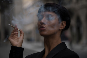 Close-up of woman smoking. Smoking. City background. Life