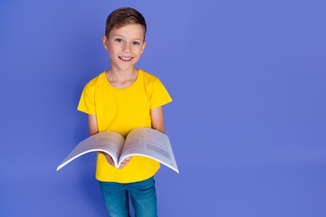 Photo of clever cheerful cute boy schoolkid wear trendy clothes read fascinating story book isolated on violet color background